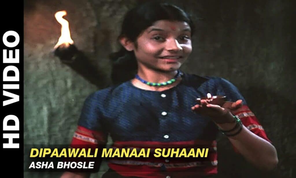 A girl smiling and holding the diya in her hand and celebrating the festival diwali by singing the song Dipaawali Manaai Suhaani Lyrics