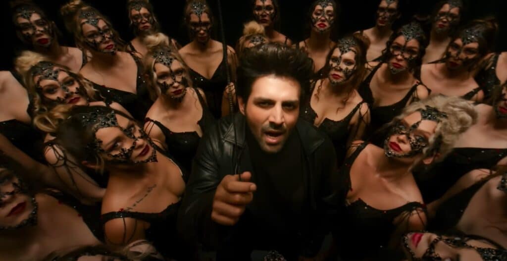 Karthik Aryan is dancing with other dancers wearing black mask and posing for Kaala Jaadu song and lyrics from the movie Freddy.